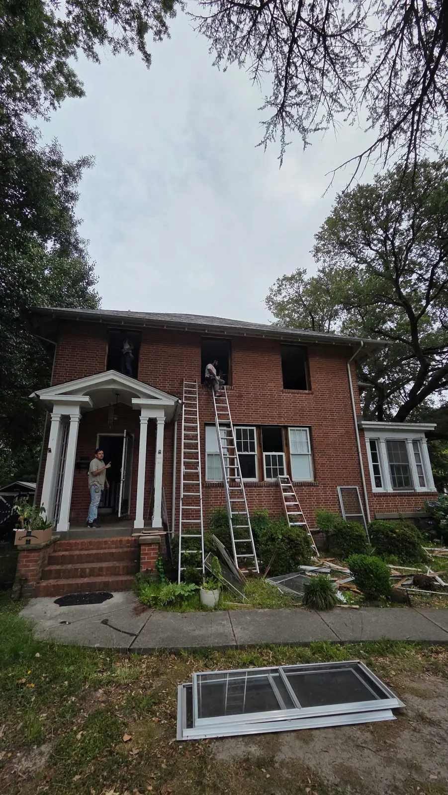 Brick colonial with new windows and a ladder for window installation in Hampton, VA