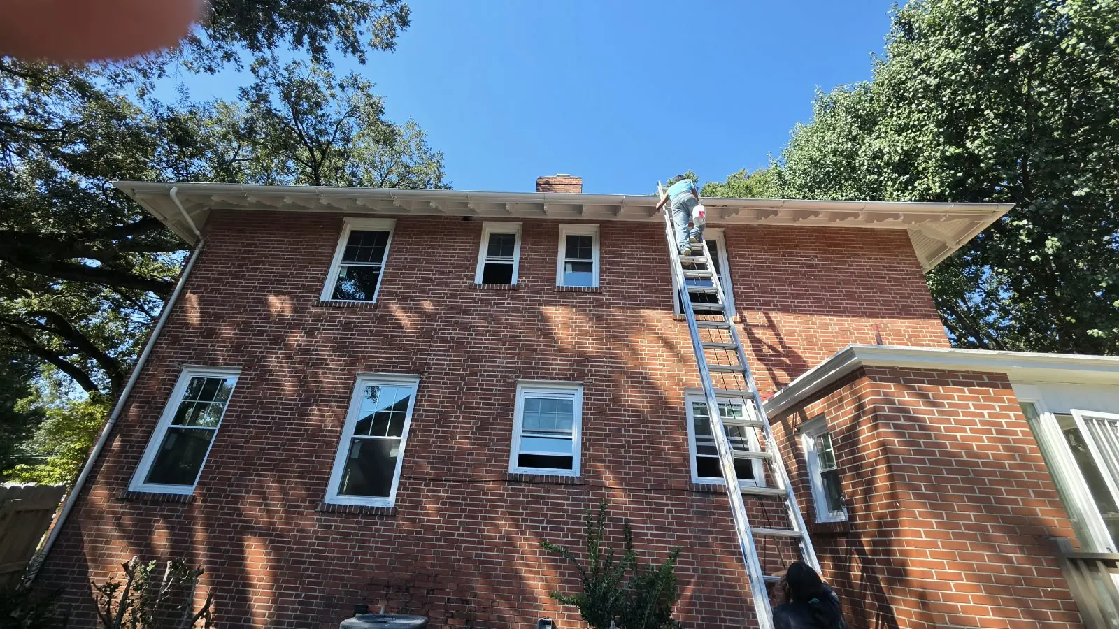 Brick house with a ladder set up for window installation by 757 Contracting Services in Hampton, VA