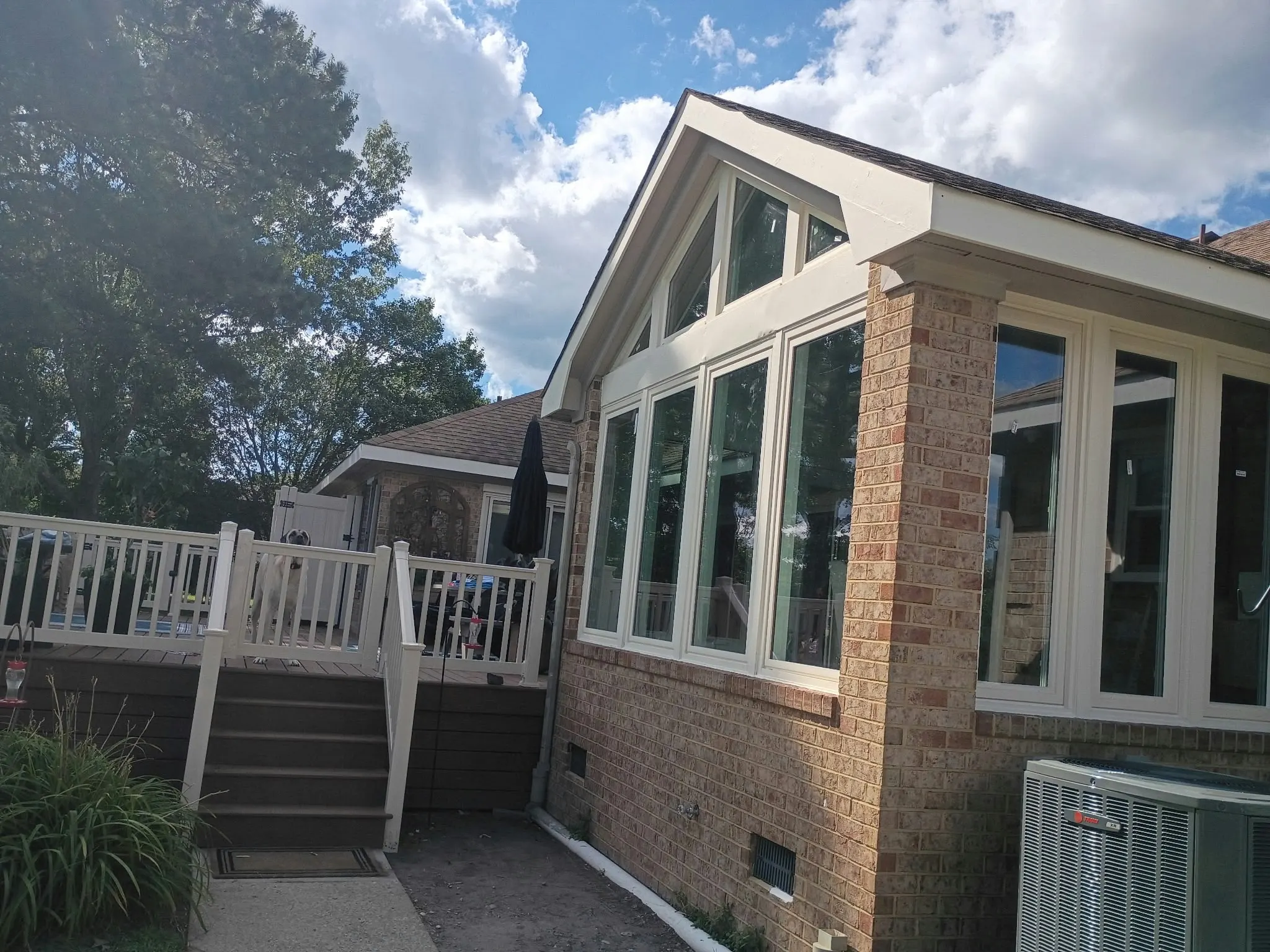 Brick home with a sunroom addition, large windows and a deck in Hampton, VA