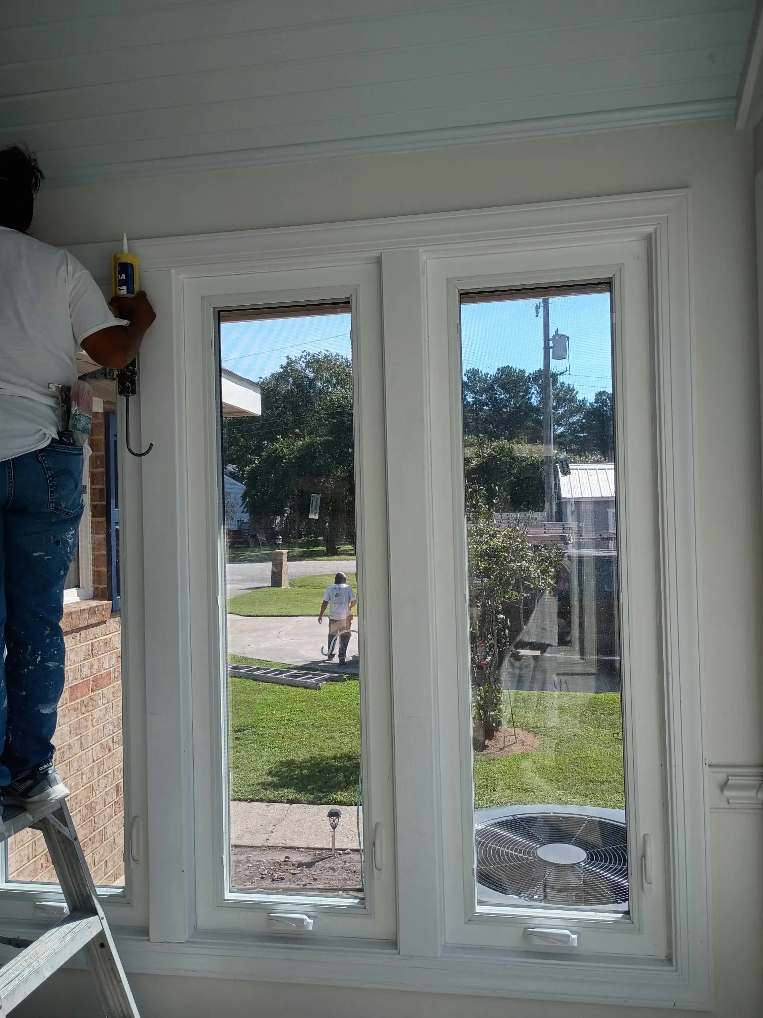 Crew member fitting new replacement windows inside a Hampton, VA home